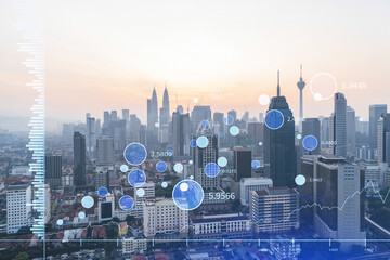 Fototapeta premium Glowing FOREX graph hologram, aerial panoramic cityscape of Kuala Lumpur at sunset. Stock and bond trading in KL, Malaysia, Asia. The concept of fund management. Double exposure.