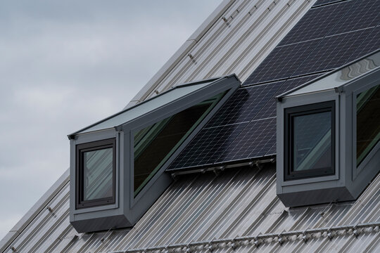 metallic windows on a top flor with a metallic sloping roof 