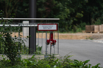 a hydrant in an industry area with a sign and trees in the background