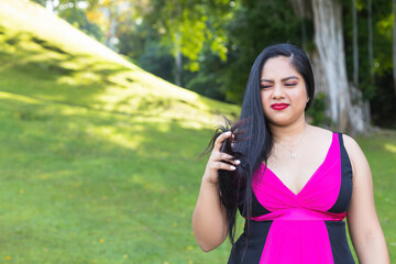 Hispanic woman taking selfie with mobile in the park