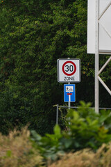a 30 kmh zone traffic sign and a dead sign in a avenue