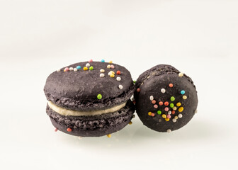 Purple cute french macarons with decorative colorful candies and white cream