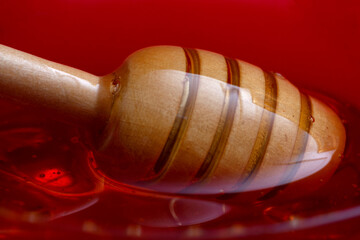 Fresh honey with stick in a glass bowl, Close-up.