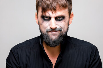 Portrait of a man with a beard and a menacing look with undead-style makeup on All Saints' Day on October 31