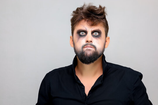 portrait of a man standing on a white background with undead-style makeup for All Saints Halloween