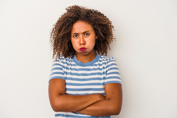 Young african american woman with curly hair isolated on white background blows cheeks, has tired...