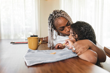 madre con su hija sentados en la mesa compartiendo con mucho amor
