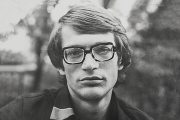 Portrait of young Soviet man with glasses. Vintage black and white paper photo, 1970s. Transferred...