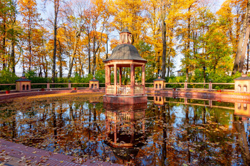 Fototapeta premium Gazebo and pond in Summer garden in autumn, Saint Petersburg, Russia