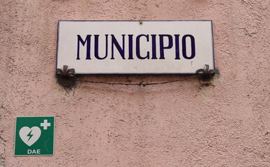 City Hall Plaque on a Pink Wall with Italian AED Sign in Antrodoco, Italy.