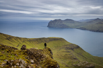 Wanderer an einer Klippe, weite Aussicht, Färöer