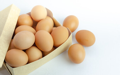 Eggs inside brown ready cardboard box, on white background. Fresh eggs for the kitchen. Copy space.