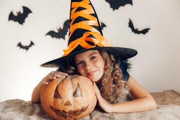 little girl dressed as a witch with a pumpkin. halloween. pumpkin for halloween