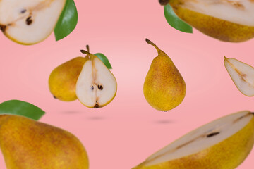 Fresh ripe whole and sliced pears flying in air isolated on a pink background.