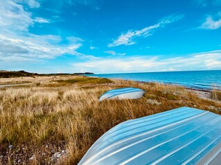 Boote im hohen Gras der Dünen, unweit des Meeres und wartend auf den nächsten Ausflug