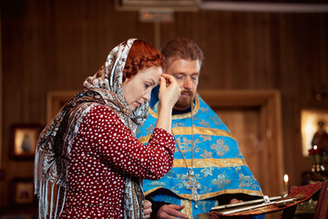 a woman repents of her sins, confessions with a priest in an Orthodox church