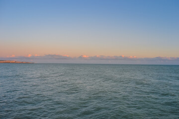 Sea at sunset, clear sky and light waves