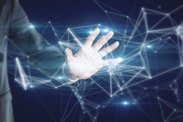 Close up of businessman hand holding abstract polygonal mesh on dark blue background. Innovation and network concept.