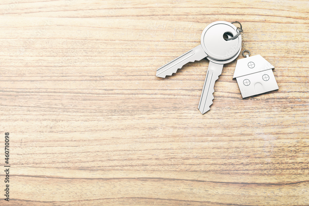 Poster close up of keys with house keychain on wooden surface background with mock up place. real estate an