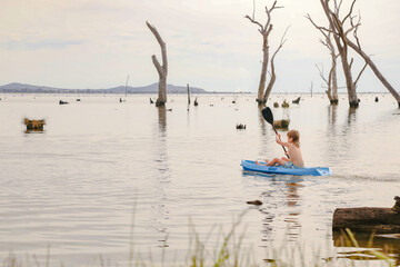 Fototapeta na wymiar Children kayaking in Summer at Kow Swamp, Victoria Australia