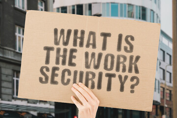 The question " What is the work security? " on a banner in men's hand with blurred background. Cyber space. Computer. Digital. Information. Privacy