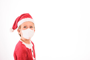 Fototapeta na wymiar A child like Santa Claus, isolated on white background, wears a mask on his face to protect himself from viruses at Christmas.