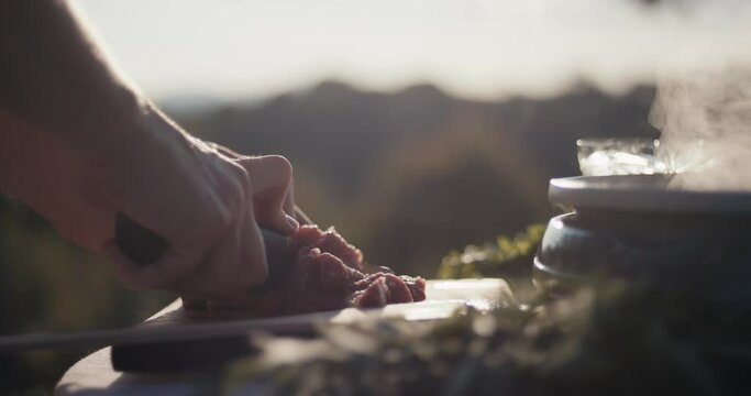 Female cut prepares raw meat cook outdoors knife in hands close up