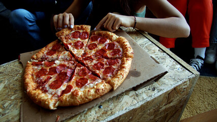 One big pepperoni pizza for a group of dancers after a training 