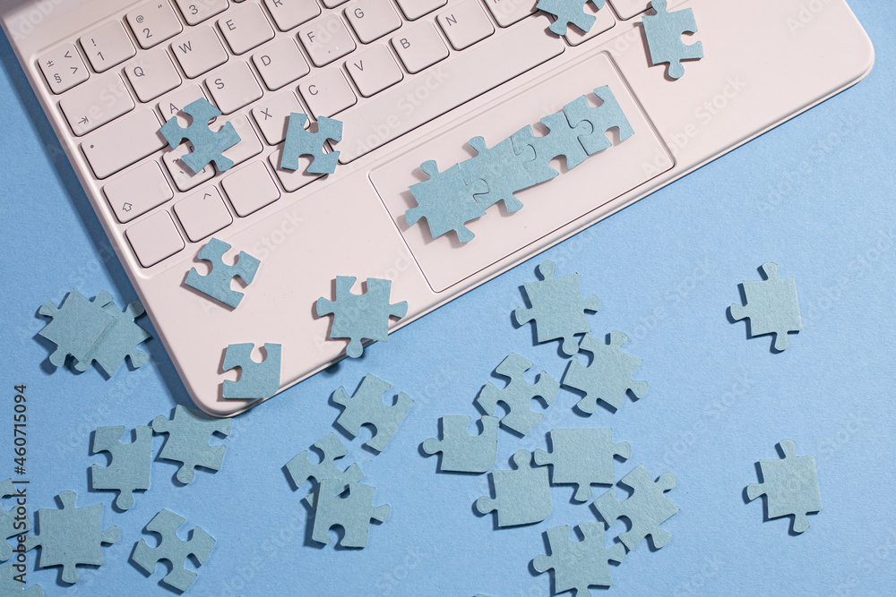 Poster puzzle elements on a laptop keyboard, software development, concept. mosaic on a blue background
