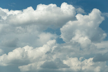 Naklejka na ściany i meble Cumuliform cloudscape on sky. Panorama. The sun is hidden. Cumulonimbus clouds.