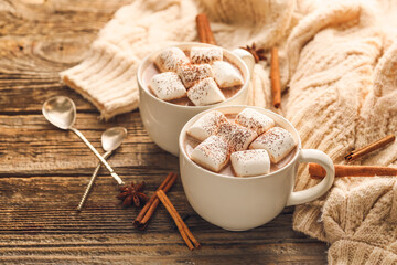 Fototapeta na wymiar Composition with cups of hot cocoa drink, marshmallows and cinnamon on wooden background