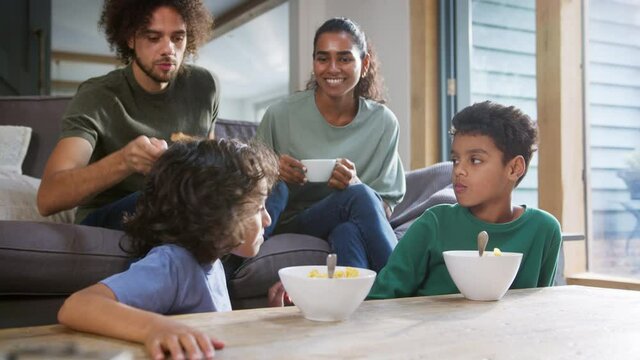 Slow motion of children eating breakfast with parents