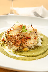 Plate with healthy baked cod fillet, rice and guacamole sauce on color background, closeup