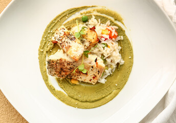Plate with healthy baked cod fillet, rice and guacamole sauce on color background, closeup