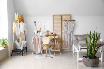 Interior of modern tailor's workshop with clothes