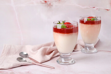 Glasses with delicious homemade strawberry panna cotta on light background