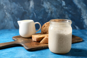 Jar with sourdough on blue background
