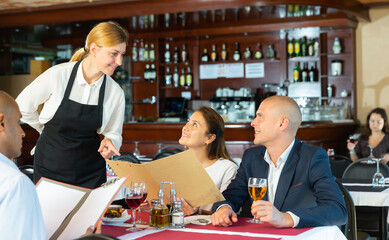 Group of business colleagues visited pizza restaurant for lunch, making order with hospitable waitress