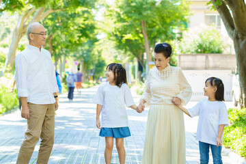 孫と一緒に散歩するシニア夫婦