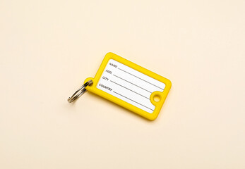 New plastic key tag on beige background