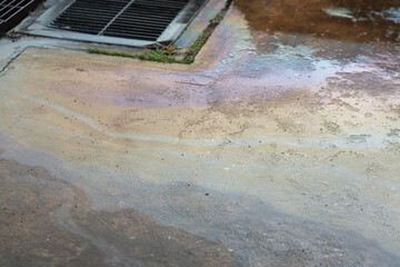 Stain of chemical or motor oil spilling on concrete ground. Industrial hazard and environmental...