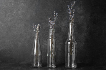 Vases with beautiful lavender flowers on dark background