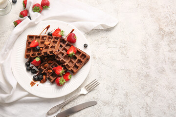 Plate of delicious Chocolate Belgian Waffles with berries and almond on light background