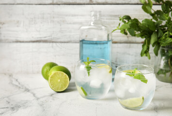 Glasses of cold gin tonic on light background