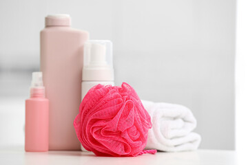 Fototapeta na wymiar Pink bath sponge and cosmetics on table