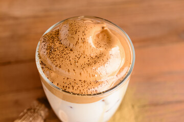 Glass of tasty dalgona hojicha on table, closeup