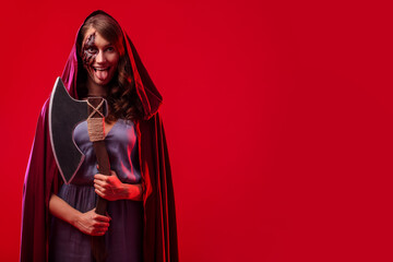 Crazy woman with Halloween makeup and axe on color background