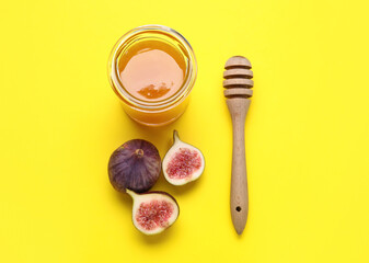 Fototapeta na wymiar Glass jar with honey and ripe figs on yellow background