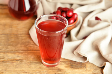 Glass of delicious dogwood drink on wooden background