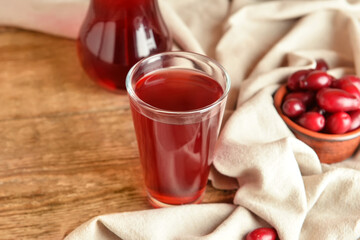 Glass of delicious dogwood drink on wooden background